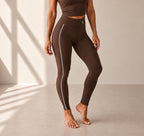 Legging Flowline chocolat – vue portée dynamique, logo blanc placé comme sur le modèle noir