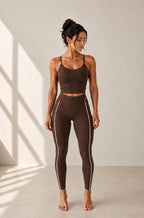 Legging Flowline chocolat – vue portée de face, logo blanc placé comme sur le modèle noir