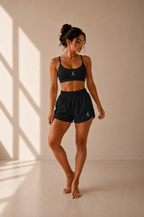 Short Run noir porté avec top noir assorti et logos blancs